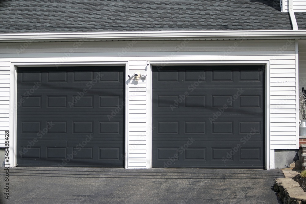 Two cars Garage Door painted in black color in a typical single house