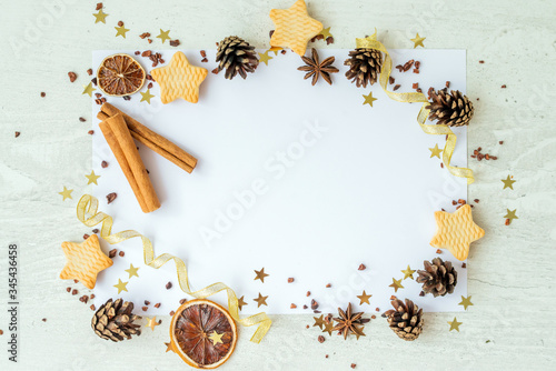 Firs, cookies, cinnamon and golden ribbons on white background. Frame reeting new year card. Christmas holiday concept. Copy space, flat lay photo