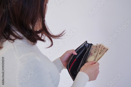 財布からお金を出す女性 photo