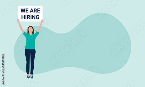 Fototapeta Naklejka Na Ścianę i Meble -  Vector illustration of a white woman in green shirt and blue pants standing on the left, holding a white sign that reads we are hiring. Sign can be changed. Isolated against a green background.