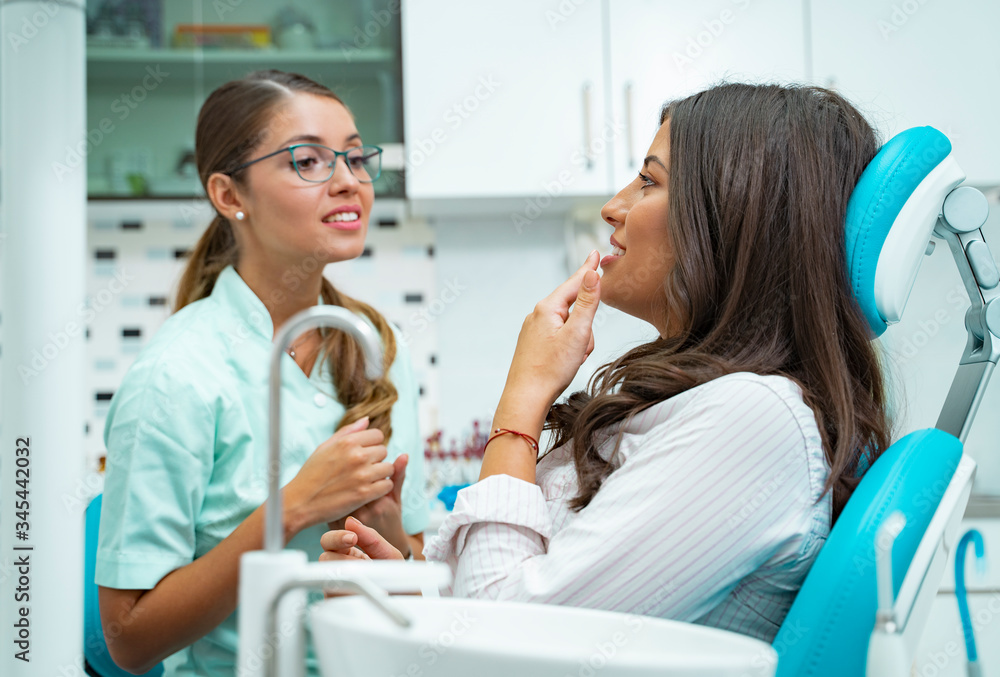 Obraz premium Patient and dentist talking, patient explaining the problem to the female doctor