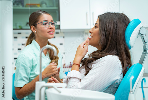 Wallpaper Mural Patient and dentist talking, patient explaining the problem to the female doctor Torontodigital.ca