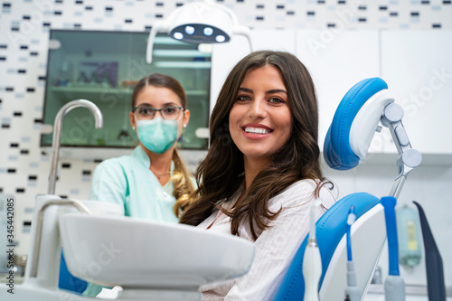 Happy patient in dental office , doctor wearing surgical mask, covid19 