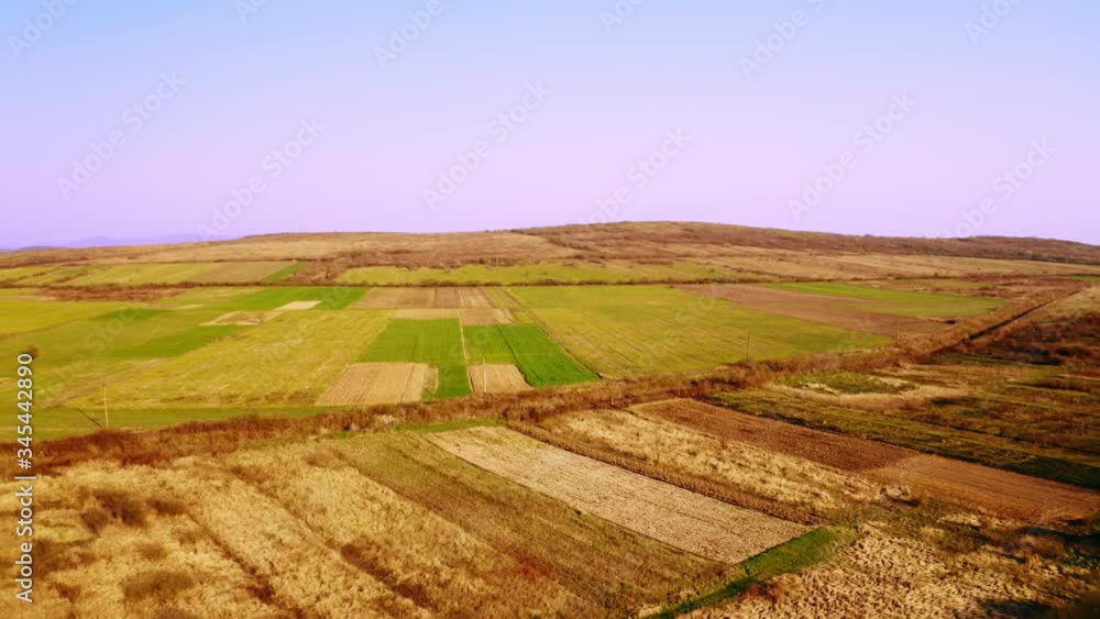 aerial shot drone flies above field and hills spring season daytime on the background mountains aerial shot drone flies above field and hills spring season daytime on the background mountains