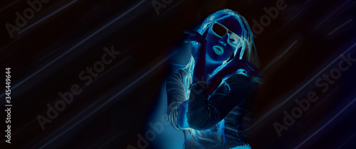 Girl with dreadlocks, pigtails dancing, bright neon photo on the cover of a music album, dance, party, invitation. Bright girl, red-blue inversion of colors. Model dancing in glasses, night club © MoreThanProd