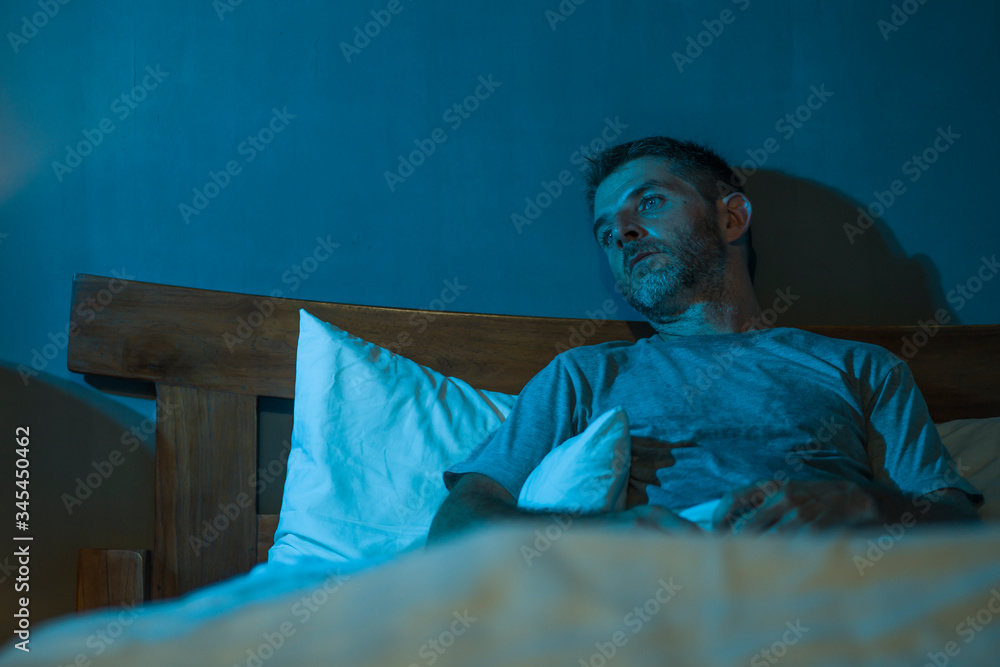 dramatic portrait in the dark of attractive depressed and worried man on bed suffering depression crisis and anxiety feeling lost lying sleepless in insomnia and life problem concept dramatic portrait in the dark of attractive depressed and worried man on bed suffering depression crisis and anxiety feeling lost lying sleepless in insomnia and life problem concept