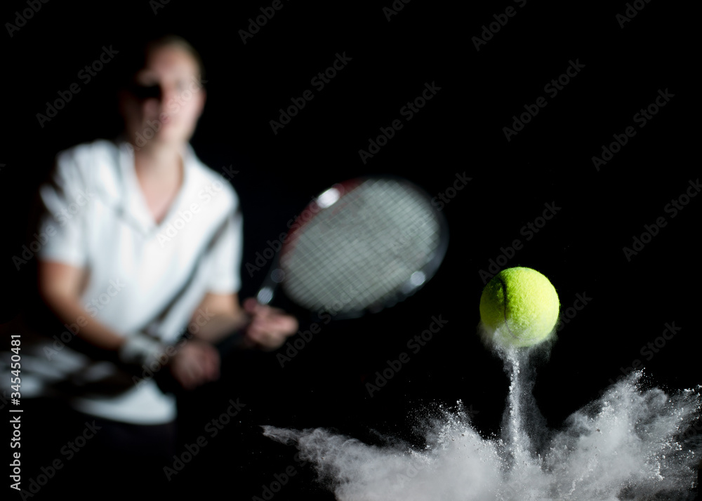 Φωτογραφία Tennis ball hitting the line and bouncing in chalk dust with young woman behind, out of focus