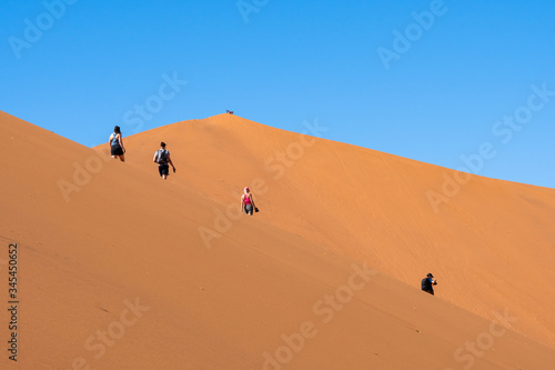 Travelers walking on the sand dune desert with clear blue sky background