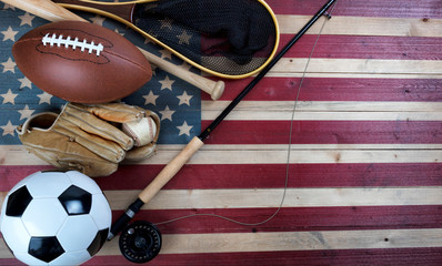 Sport equipment for baseball, football, soccer and fishing on vintage wooden USA flag