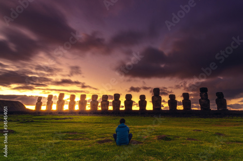
person contemplates a magical sunrise on easter island photo