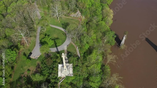 Aerial descent and camera tilt up focussed on the James Rumsey Monument with Shepherd University in the distance in Shepherdstown, WV. photo