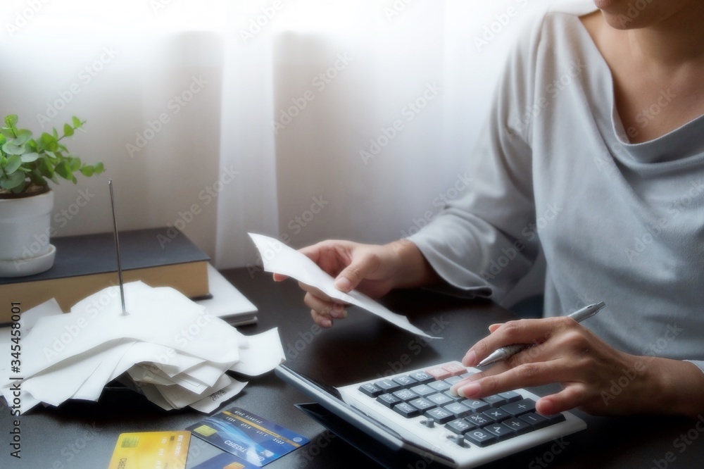 Φωτογραφία Hand of Asian woman pressing a calculator for check of bill, receipt, report, financial statement of credit card