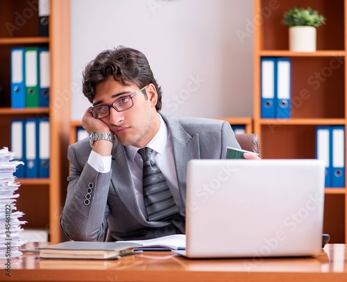 Young handsome businessman unhappy with excessive work