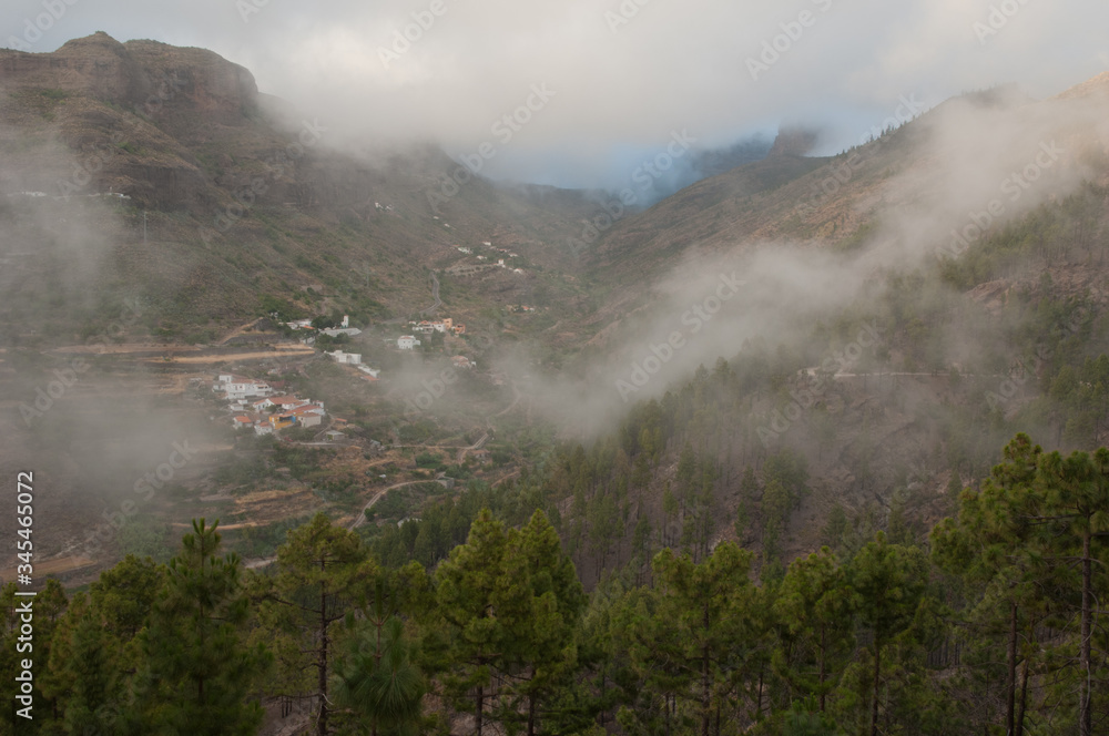 Village of El Juncal in the fog. El Juncal ravine. The Nublo Rural Park. Tejeda. Gran Canaria. Canary Islands. Spain.