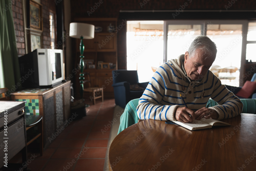 Senior man writing at table Senior man writing at table