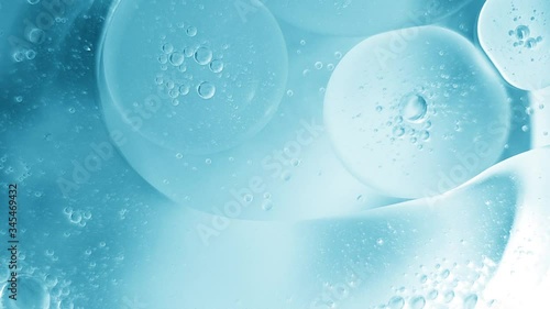 bubbles oil drops in motion on the water surface, blue abstract background