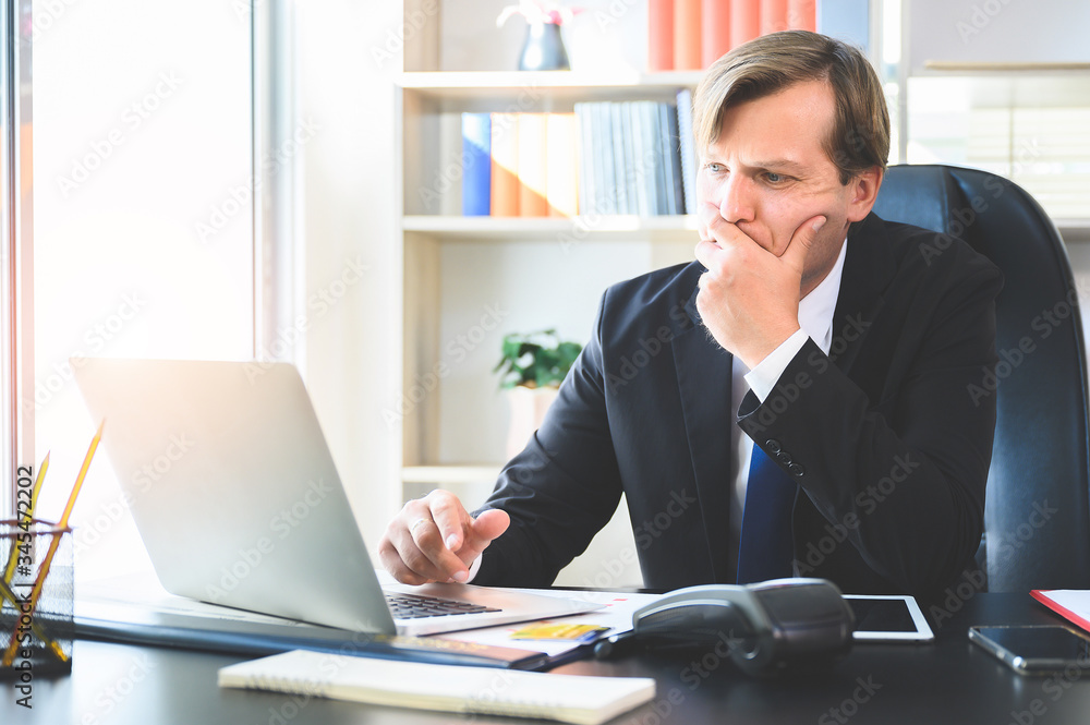 Young business man are busy working in the office. He using laptop on desk in office room Young business man are busy working in the office. He using laptop on desk in office room
