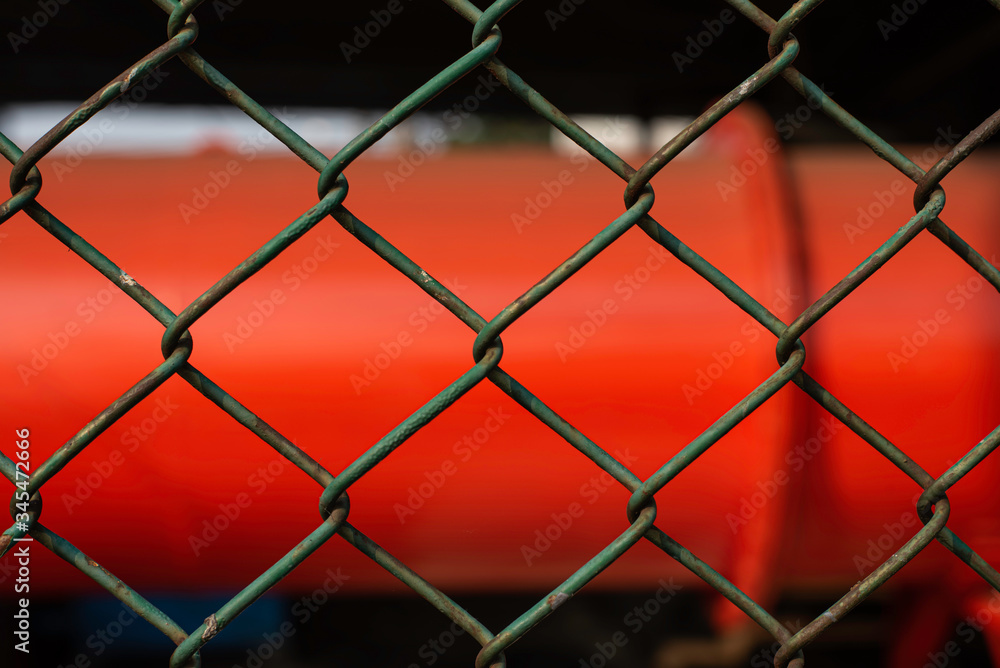 Fototapeta premium old and rusty green chain fence puts up on factory for security reason