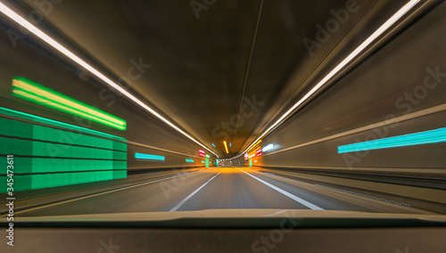 Fast moving with my car through a tunnel with leading lines and lights and blur effect.