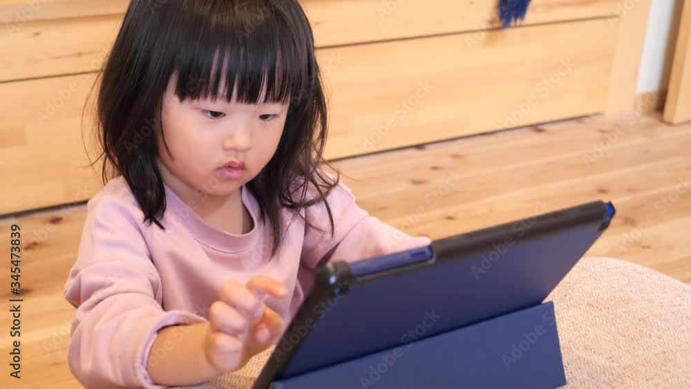 Three-year-old Japanese girl playing with a tablet Three-year-old Japanese girl playing with a tablet