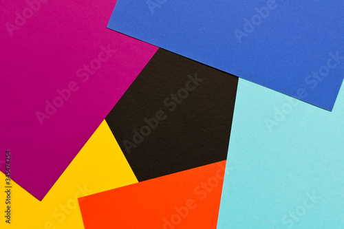 Multi-colored abstract geometric background. Colored sheets of paper on a dark background. Trending colors 2020.
