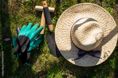 Straw sunhat with gloves and garden tools