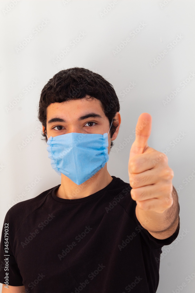 young man wearing a blue medical mask on a white background gesturing with his hands that everything will be fine young man wearing a blue medical mask on a white background gesturing with his hands that everything will be fine