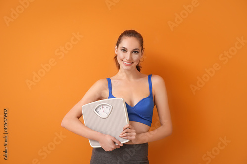 Young woman with weight sca...