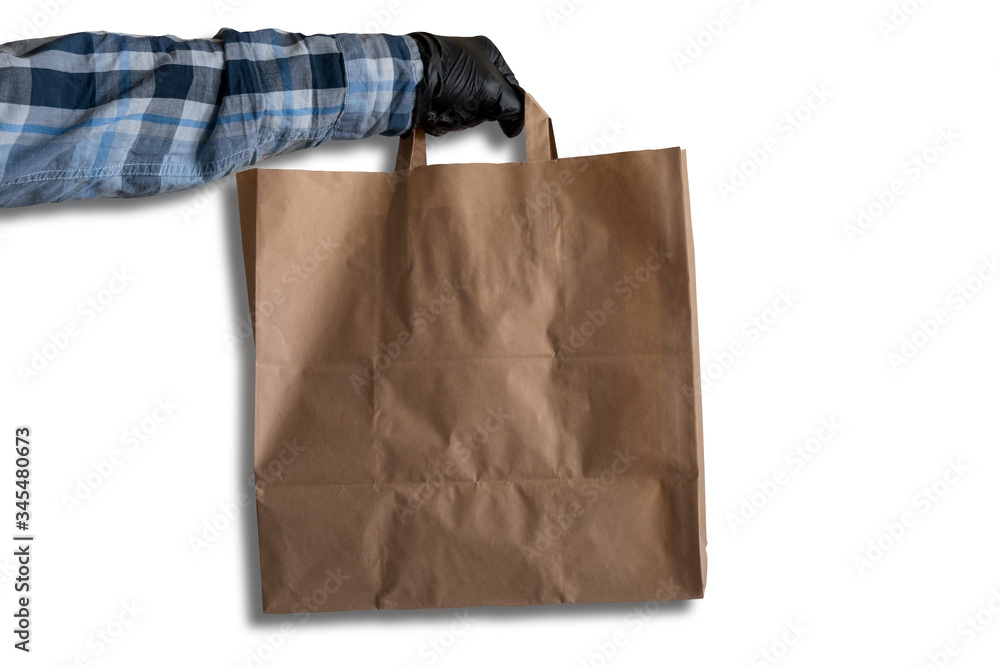 a man's hand in black gloves holds a paper bag on a white background, mock up paper bag, delivery concept