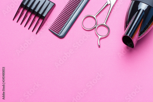 A set of tools for the hairdresser, hairdryer, scissors, comb, on a pink background, copy of the space photo