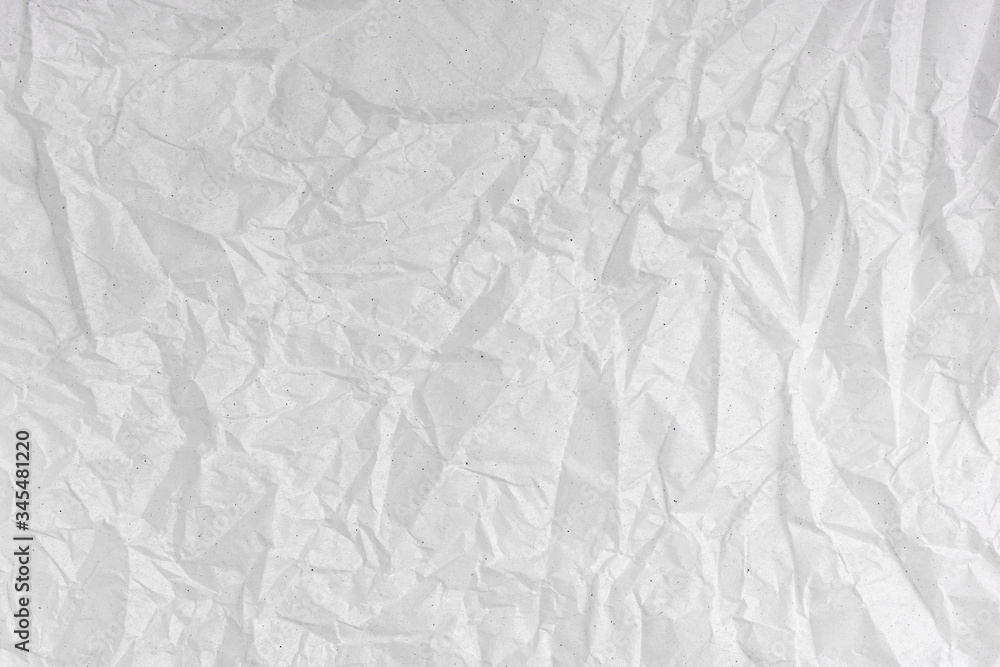 White wrinkled creased paper texture. Blank crumpled grainy paper textured surface.