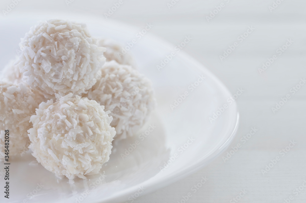 Candies in plate covered by chocolate and shredded coconut on rustic wooden background. Candies in plate covered by chocolate and shredded coconut on rustic wooden background.