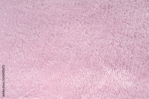 Fluffy pink synthetic fabric background. Soft plush pastel textile texture of winter clothing