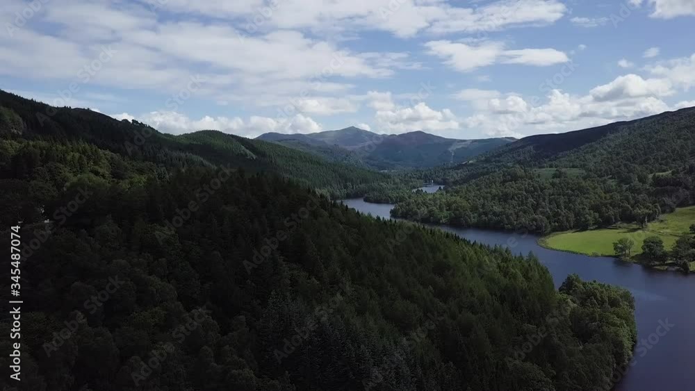 Aerial view over forrest and Loch Tummel revealing mountains in the background on a cloudy summer day. Aerial view over forrest and Loch Tummel revealing mountains in the background on a cloudy summer day.