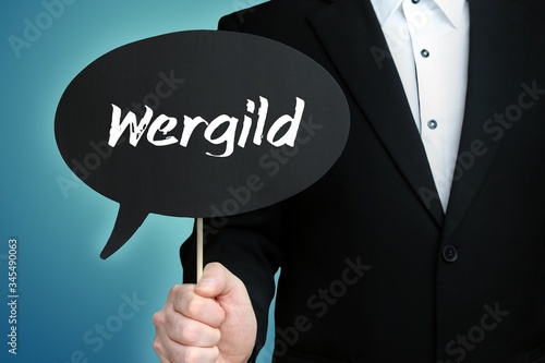 Wergild. Lawyer in suit holds speech bubble at camera. The term Wergild is in the sign. Symbol for law, justice, judgement photo