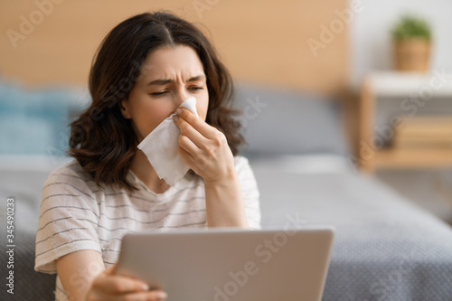 girl is holding paper tissue and blowing nose