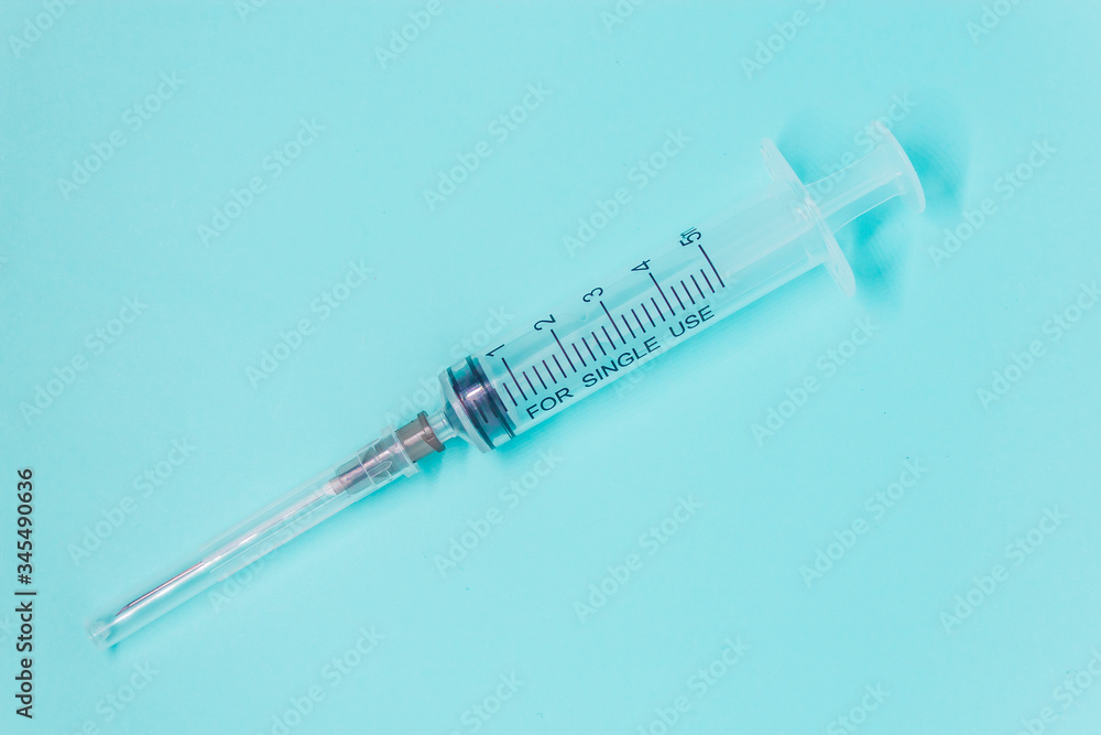 transparent medical syringe on blue background close up layout. Medical examination and treatment concept transparent medical syringe on blue background close up layout. Medical examination and treatment concept