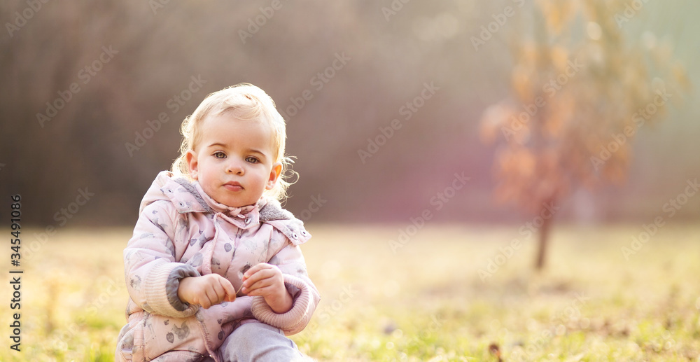 Baby girl sitting on grass on sunny day Baby girl sitting on grass on sunny day
