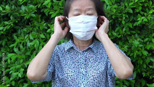 Senior asian woman is wearing face mask to prevent covid-19 or coronavirus infection as a social distancing guideline during outbreak. new normal lifestyle concept 