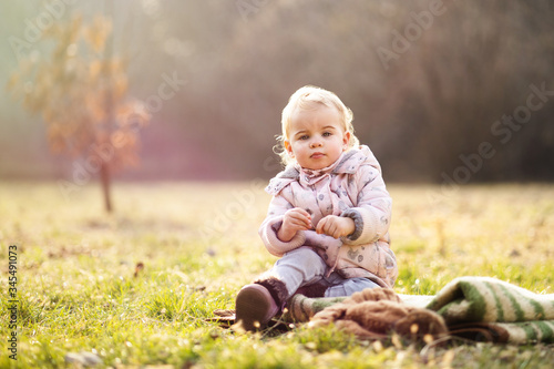 Baby girl sitting on grass on sunny day