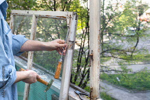 Repair restore old wooden windows using a hammer and a screwdriver. Repairing interior of old house. Close-up of home DIY