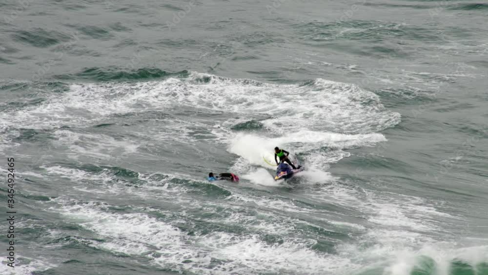 Watercraft rescues surfist in Nazarè in Portugal. High angle Watercraft rescues surfist in Nazarè in Portugal. High angle