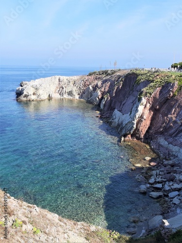 evocative image of a marine promontory with a steep coast, sea and blue sky in summer