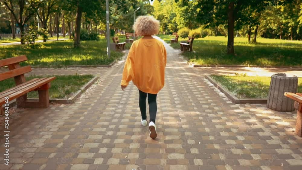 young blonde woman walking on the street summer landscape slow motion young blonde woman walking on the street summer landscape slow motion
