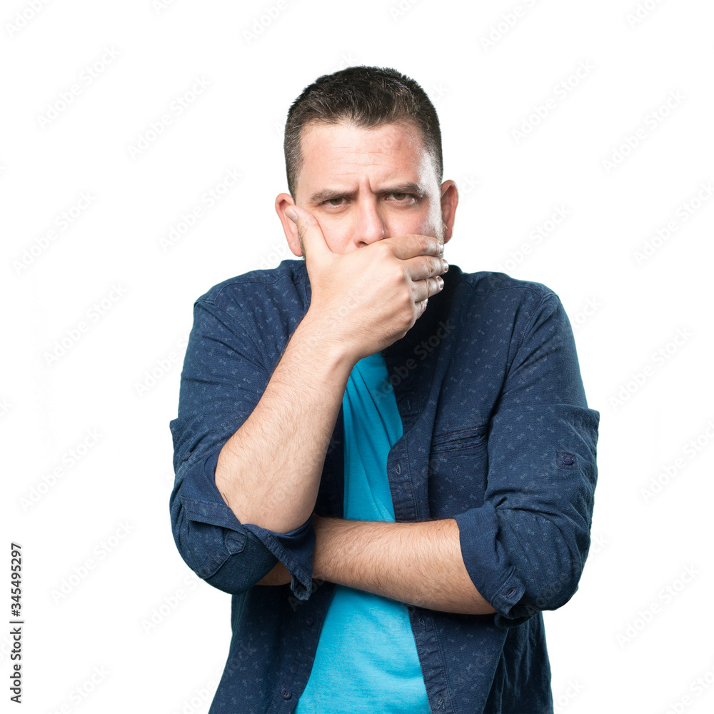 Young man wearing a blue outfit. Looking seriuos and covering his mouth with his hand. Young man wearing a blue outfit. Looking seriuos and covering his mouth with his hand.