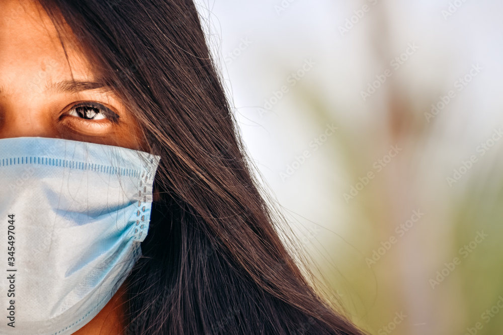 Closeup shot of face of an Indian girl wearing medical mask during the Coronavirus pandemic Closeup shot of face of an Indian girl wearing medical mask during the Coronavirus pandemic