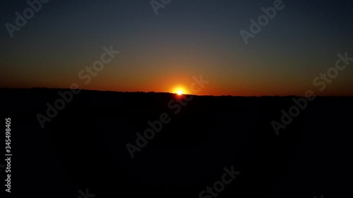 Wallpaper Mural Aerial wide shot showing beautiful sunset at horizon going down behind mountain Torontodigital.ca