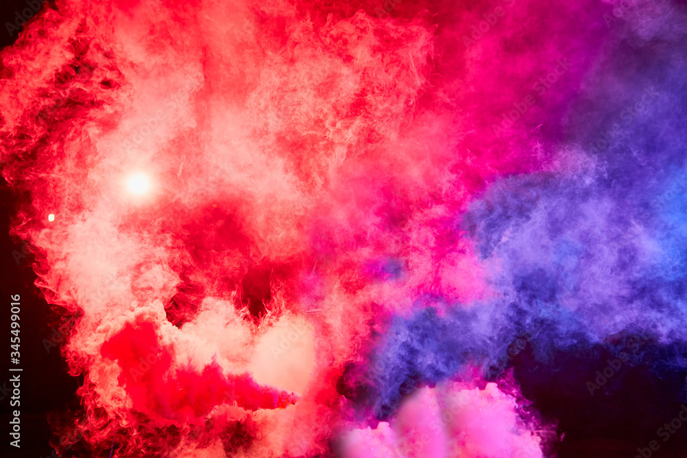 Fototapeta premium Color smoke on black background. Colorful red and blue background for photo shoot. Colored smoke illuminated by flash