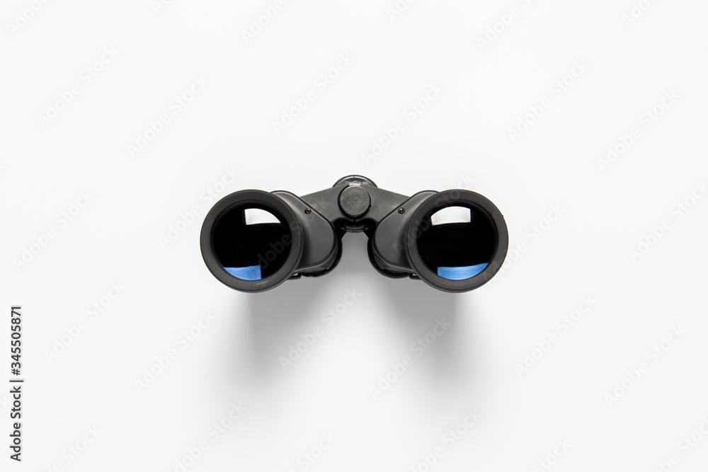 Black binoculars on a white background. Flat lay, top view Black binoculars on a white background. Flat lay, top view
