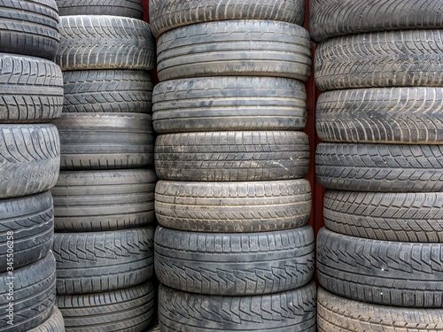 Used car tires stacked in piles.Worn out rubber tires.